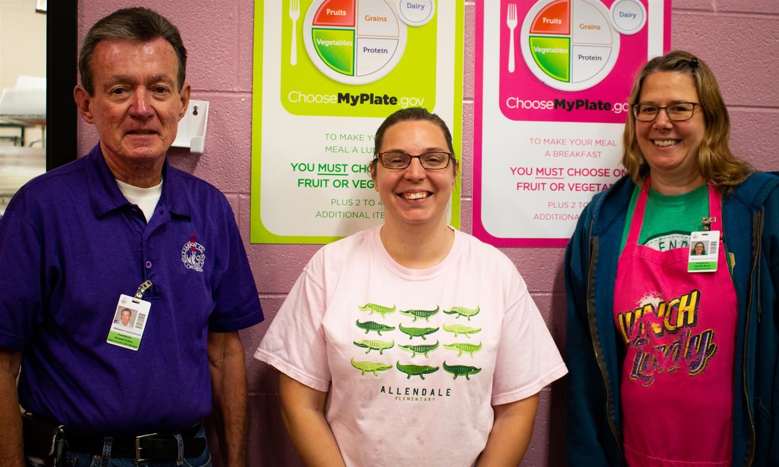 Three cafeteria workers smile